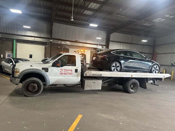 TJ Towing flatbed transporting a luxury Tesla in New Orleans